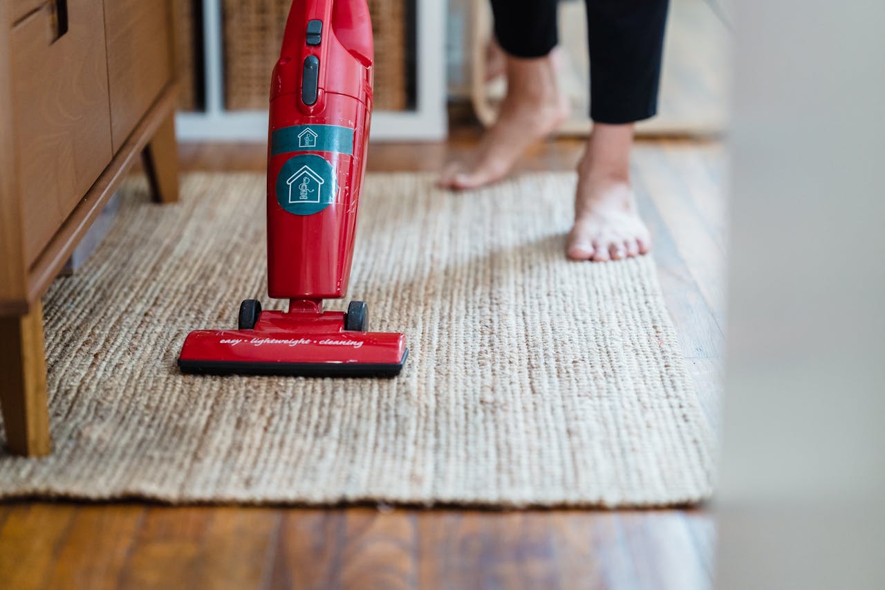journey A red vacuum cleaner on a carpet in a stylish home setting with barefoot user.
